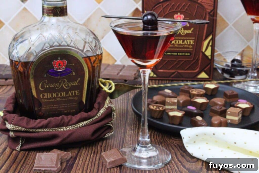 Crown Royal Chocolate Manhattan 8 chocolate manhattan cocktail in coupe glass with cherry skewer next to chocolate crown royal bottle and chocolate candies