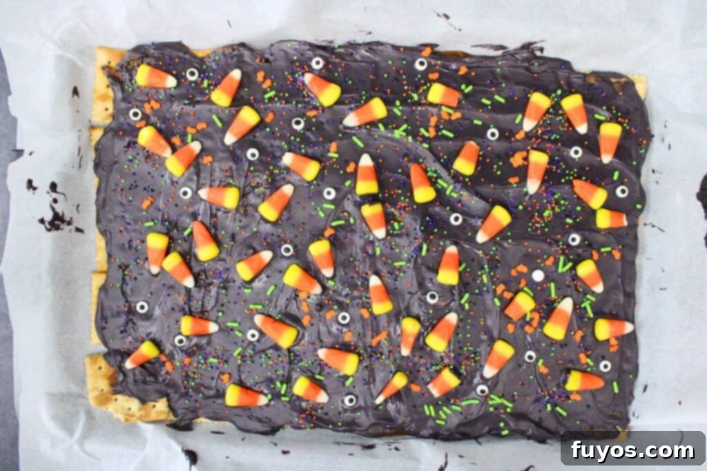 No Bake Halloween Saltine Crack Toffee 9 Topping Halloween crack with a variety of Halloween candy decorations, including sprinkles and candy corn, while the chocolate is still wet.
