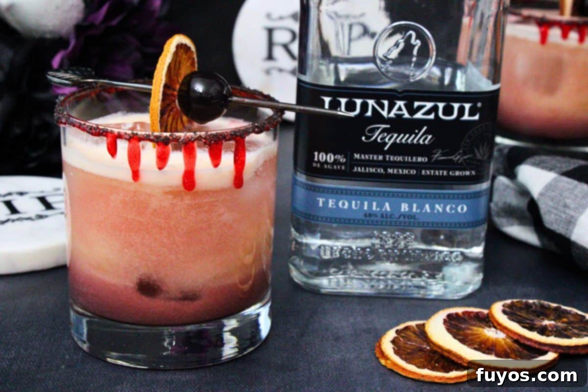 11 Easy Tequila Cocktails: Spooktacular Sips for Halloween 6 closeup of bloody tequila sunset garnished with a skewer of blood orange and cherry