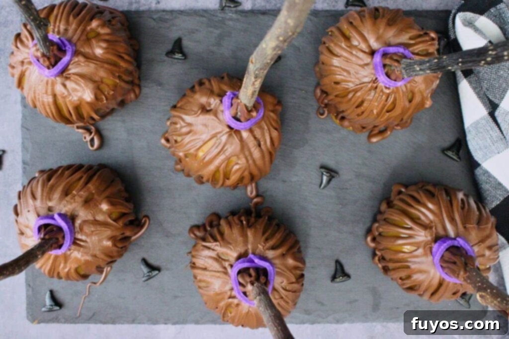No-Bake Caramel Apple Broomsticks 10 overhead view of caramel apple broomsticks on a piece of slate