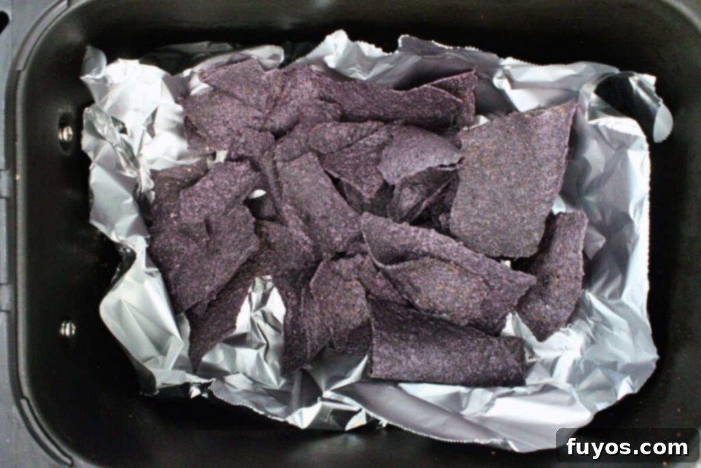 Air Fryer Halloween Monster Pumpkin Nachos 8 spread blue corn tortilla chips in air fryer basket