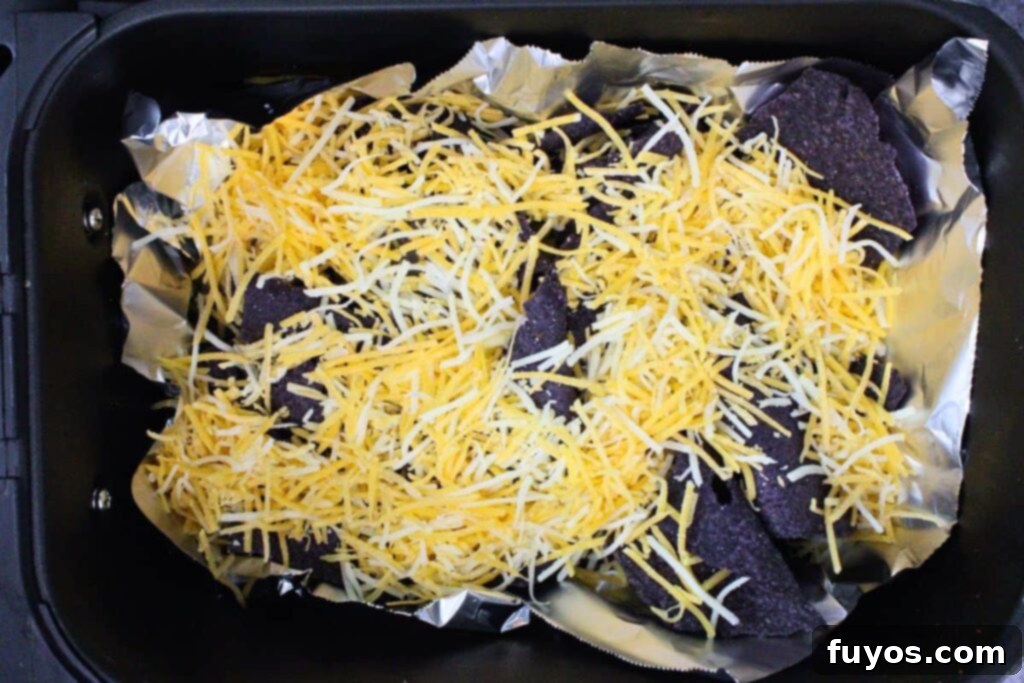 Air Fryer Halloween Monster Pumpkin Nachos 9 sprinkle half the cheese over blue tortilla chips