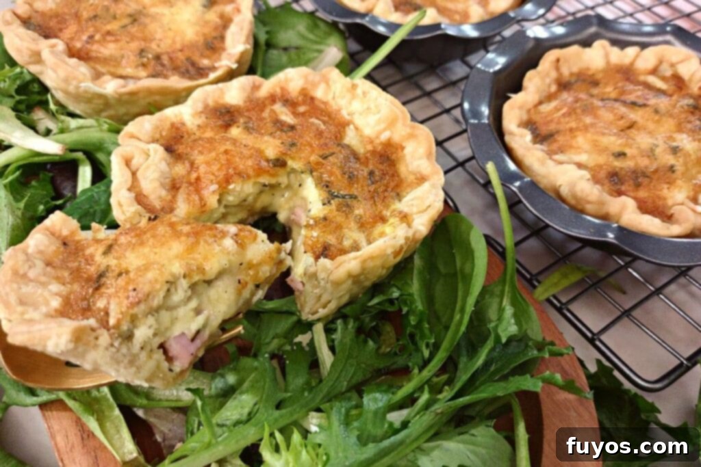 cutting out a triangle slice of ham and cheese quiche and holding it on a fork