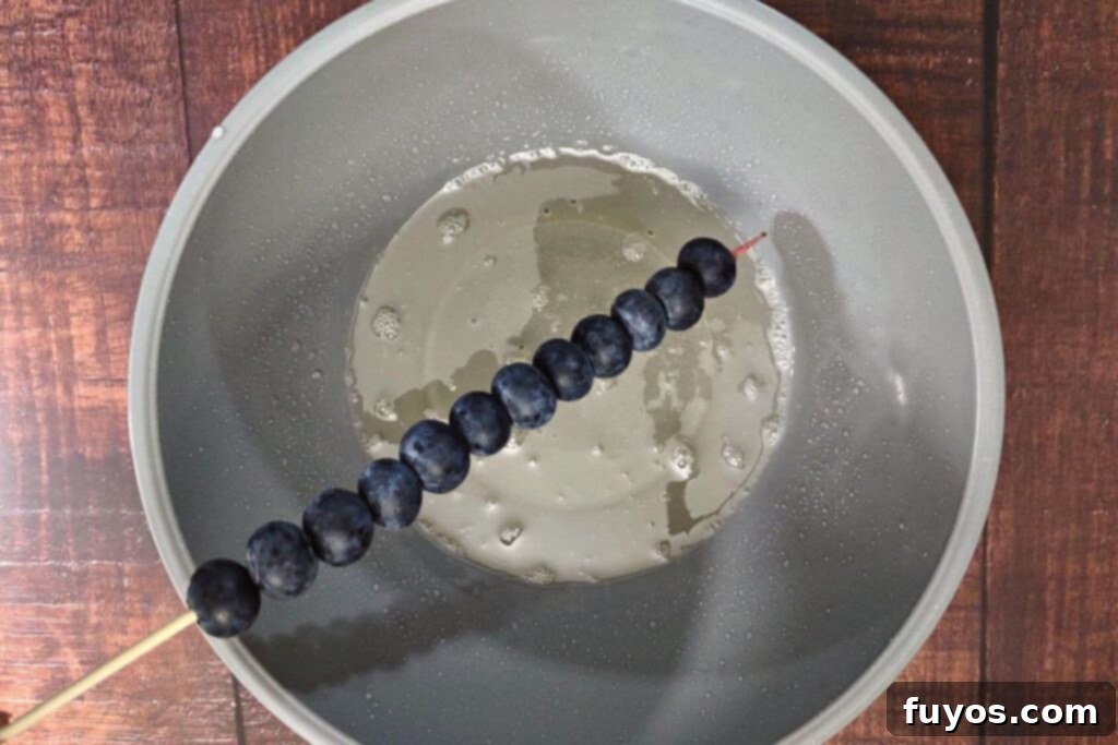 Microwave Tanghulu: The Easiest Candied Fruit Recipe 8 dip fruit skewer into heated sugar mixture
