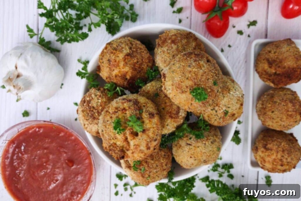 Crispy Air Fryer Arancini Mozzarella Stuffed Rice Balls 13 overhead view of arancini rice balls with marinara dipping sauce on the side, ready to serve