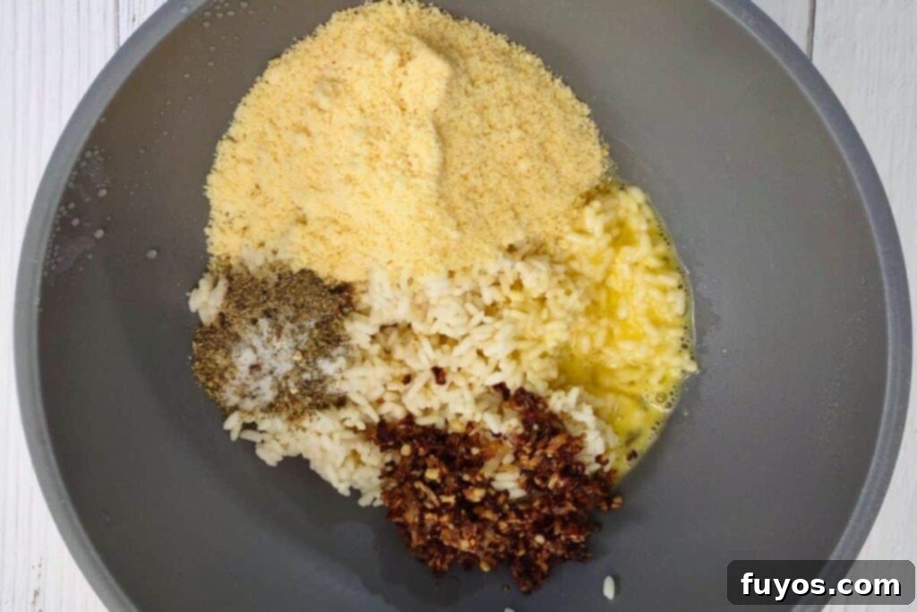 Crispy Air Fryer Arancini Mozzarella Stuffed Rice Balls 5 add rice, eggs, parmesan cheese, seasoning, and butter mixture to a bowl for arancini