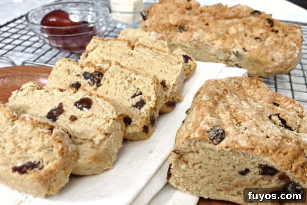 slices of irish soda bread with raisins next to the loaf half