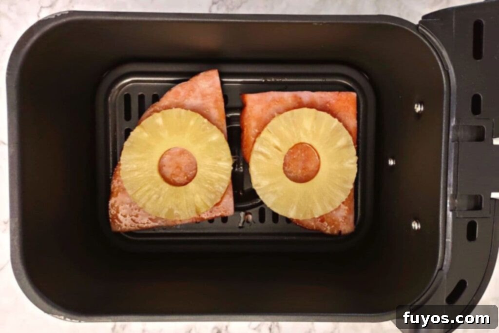 Flip ham steak, add glaze and pineapple to air fryer