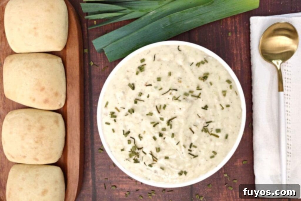 Creamy Air Fryer Leek and Potato Soup Pure Comfort Made Easy 12 Overhead view of creamy air fryer potato leek soup in a bowl with fresh rolls