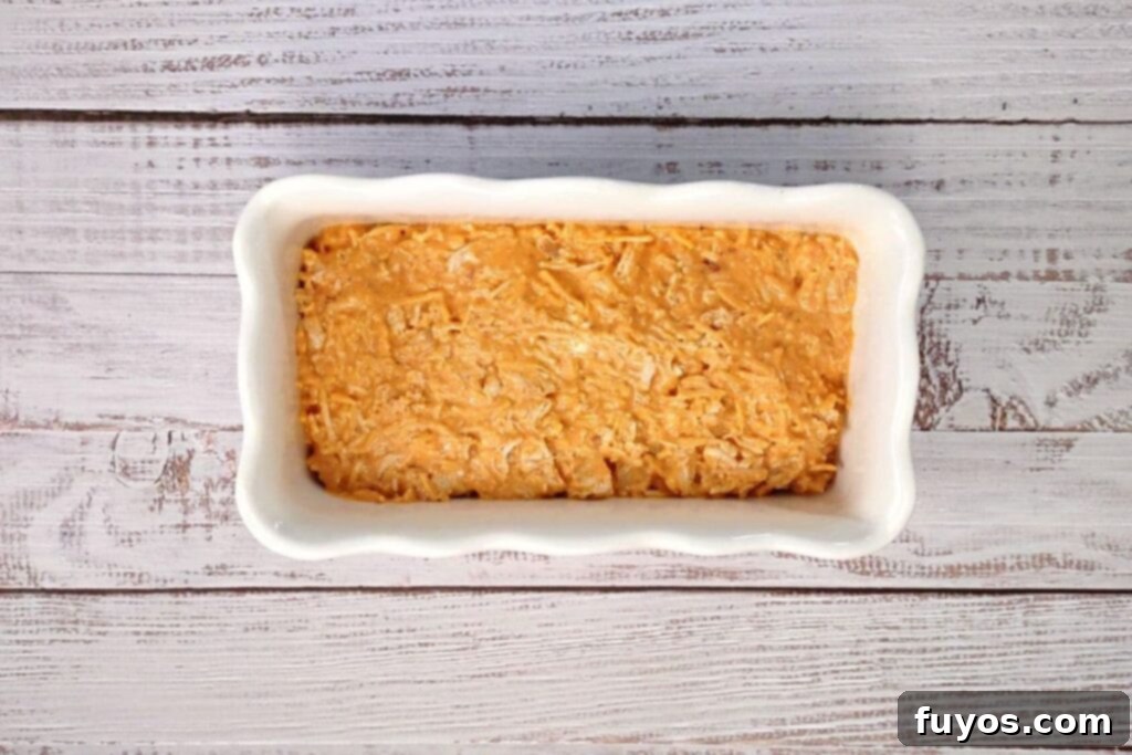 Ultimate Air Fryer Buffalo Chicken Dip 6 Mixed buffalo chicken dip spread into an oven-safe casserole dish for the air fryer.