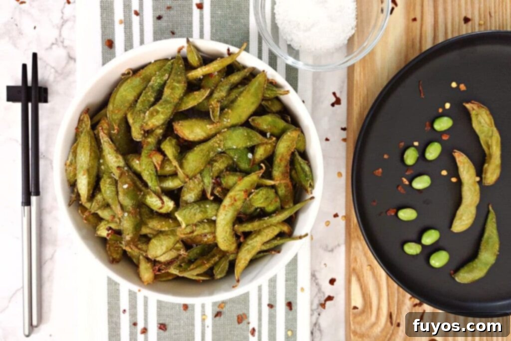 Overhead view of air fryer spicy garlic edamame in a white bowl