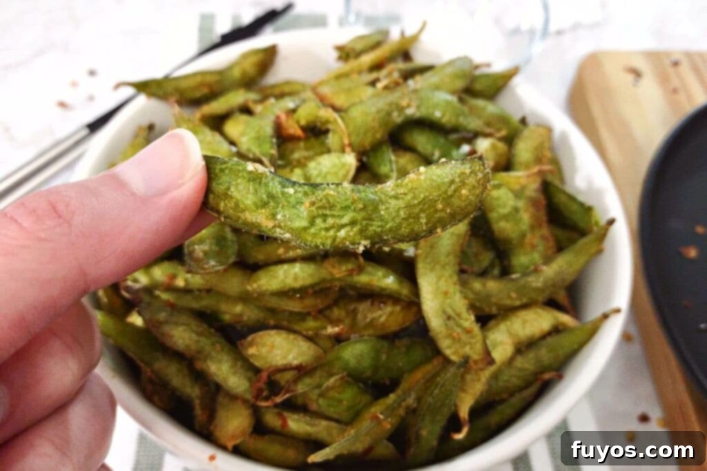 Holding an air fried spicy garlic edamame