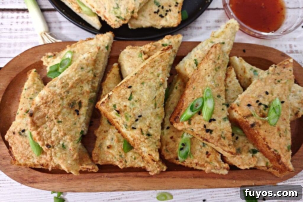 stacked air fryer shrimp toast triangles on a wooden platter
