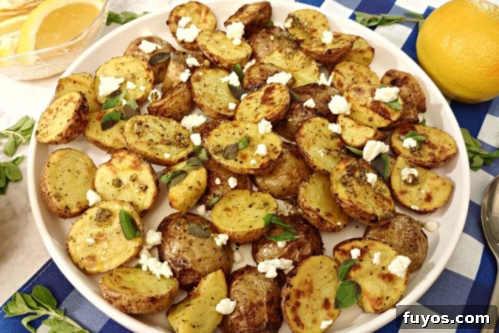 air fryer greek potatoes on a plate with feta cheese on top and lemons for decoration