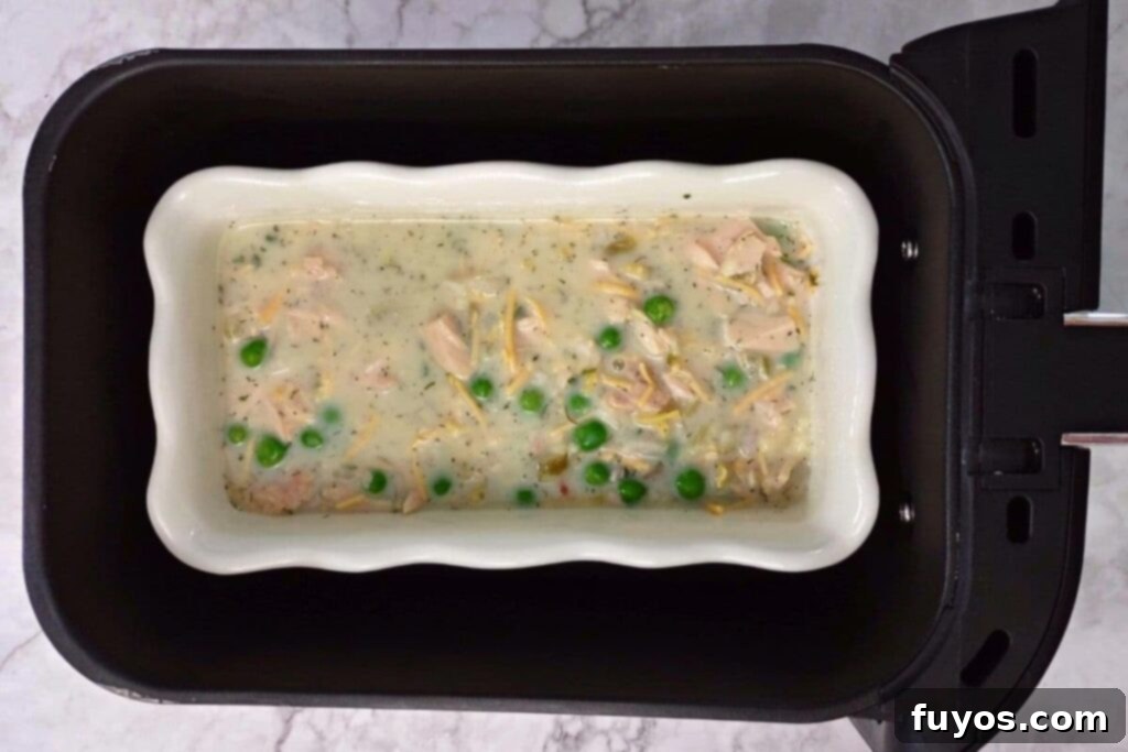 Air Fryer Tuna Casserole Your Perfect Comfort Indulgence 8 Casserole dish with tuna noodle mixture placed inside an air fryer basket.