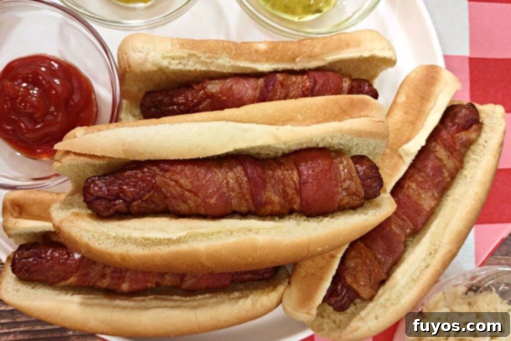 Air Fryer Bacon Hot Dogs: Crisp Perfection, Zero Fuss 9 air fryer bacon wrapped hot dogs stacked up on a plate