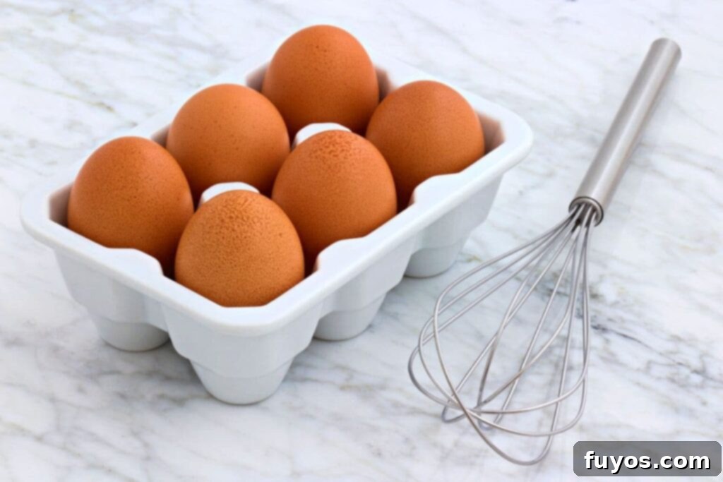 Unlock Gourmet: 10 Box Cake Transformations 3 brown eggs in a container next to a whisk