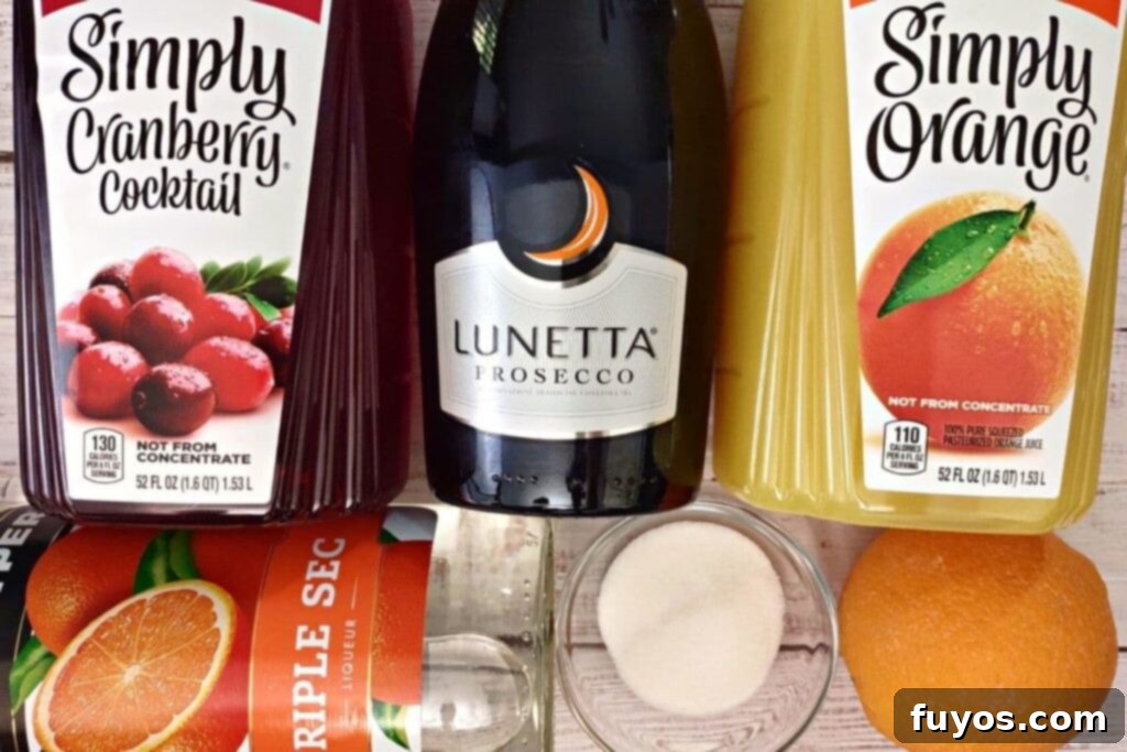 Cranberry Orange Mimosa Brunch Celebration 4 All the essential ingredients neatly laid out for making cranberry orange mimosas with triple sec, including a bottle of Prosecco, juices, and oranges