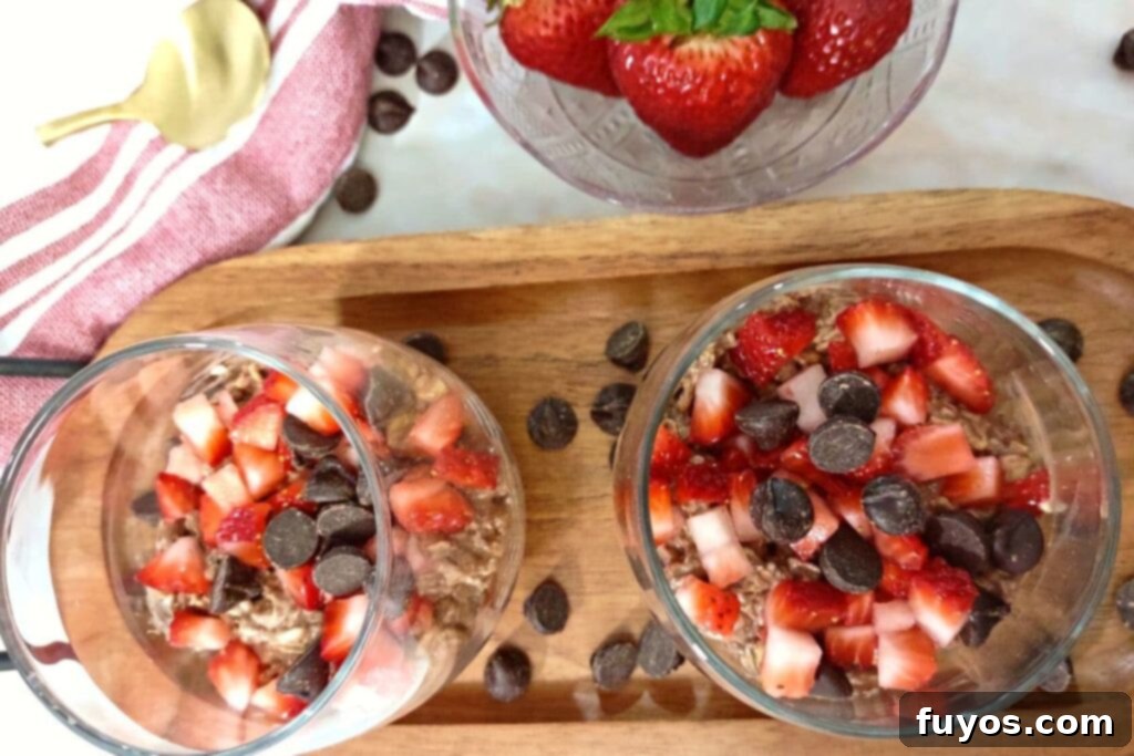 glasses of overnight oats with strawberries and chocolate on top