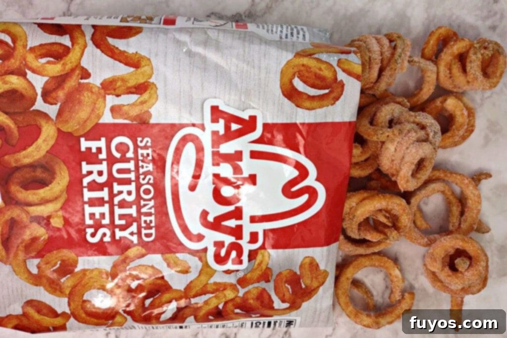 A bag of frozen Arby's curly fries, still in its packaging, ready for air frying.