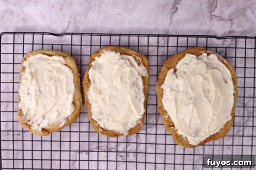 spread the cream cheese frosting over the cooled cookies