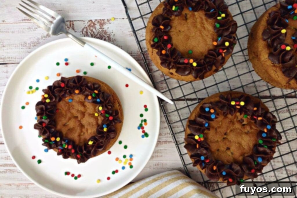 Overhead shot of an air fryer cookie cake topped with fudge icing and colorful sprinkles
