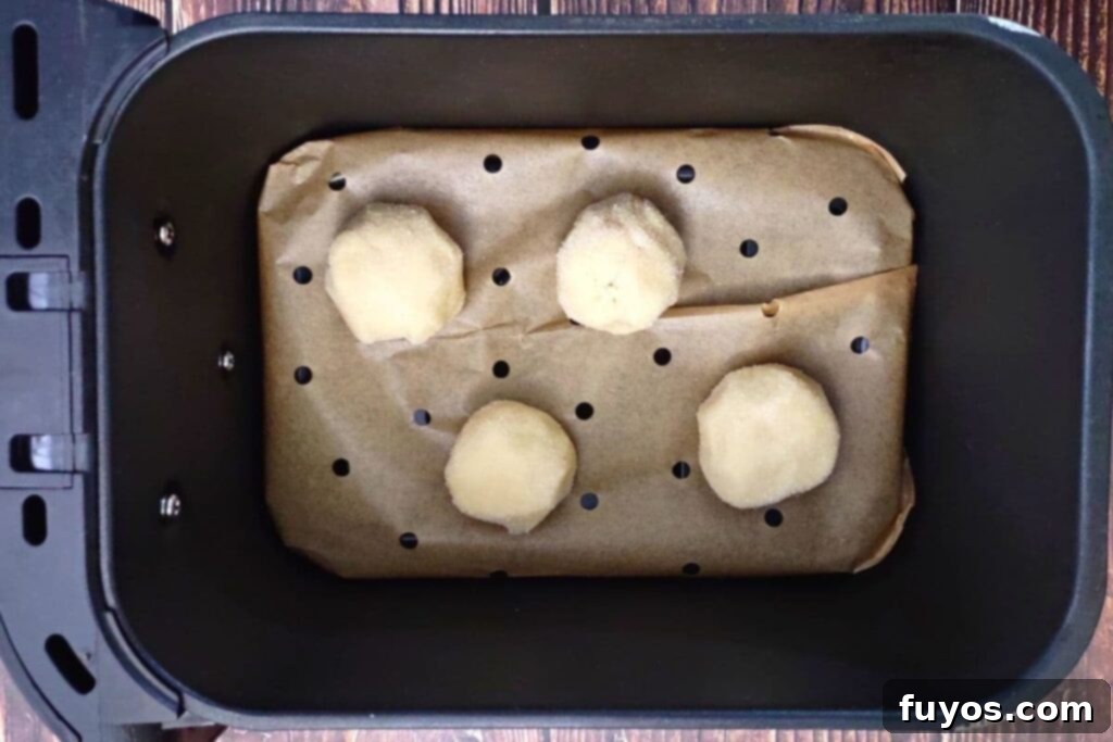 Southern Comfort Tea Cakes Air Fried 10 Placing cookie dough balls spaced apart in an air fryer basket.