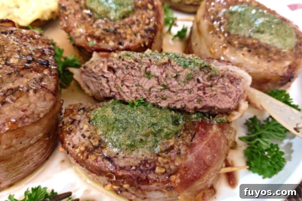 juicy bacon wrapped filet cut in half and laying on a plate