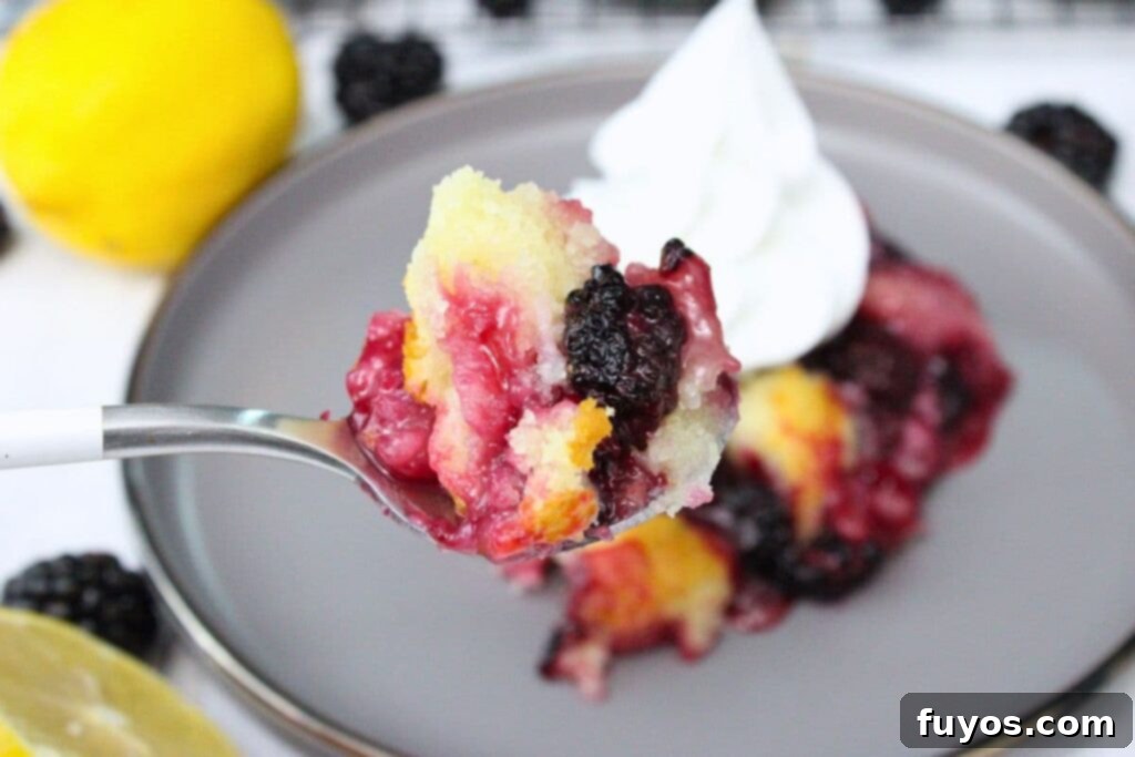 Effortless Air Fryer Blackberry Cobbler A Summer Delight 3 holding up a spoonful of air fryer blackberry cobbler