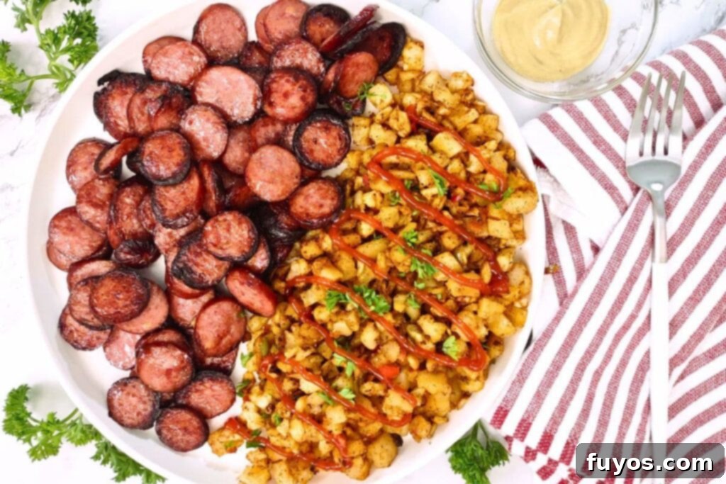 Perfect Smoked Sausage in Your Air Fryer 7 overhead view of air fryer smoked sausage on a white plate with potatoes and onions