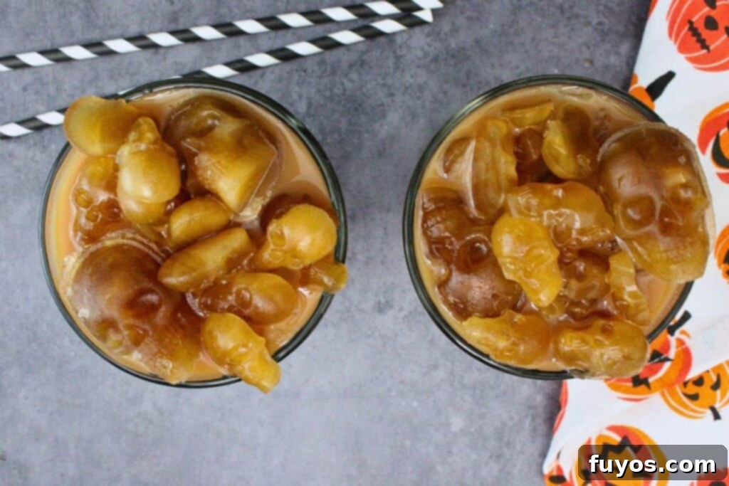 Halloween's Dearly Depar-tead Brown Sugar Skull Milk Tea 9 overhead view of two skull milk tea drinks with lots of brown sugar ice skulls on a dark counter