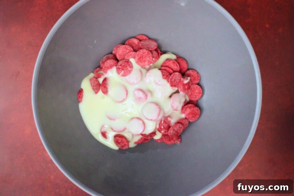 Vampire Fudge: A Sinfully Simple Halloween Indulgence 5 Red candy melts and half a can of sweetened condensed milk in a microwave-safe bowl, ready to be melted for the first layer of vampire fudge.