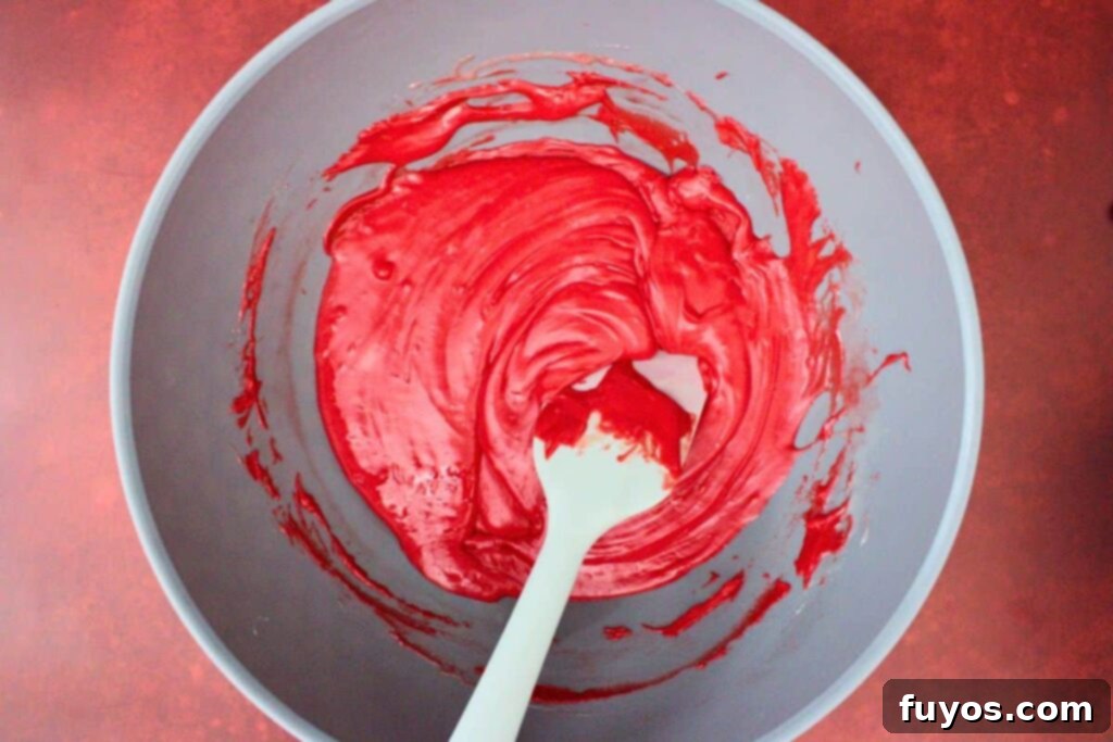 Vampire Fudge: A Sinfully Simple Halloween Indulgence 6 Melted red fudge mixture, smooth and vibrant, in a microwave-safe bowl, representing the first layer of the vampire fudge.