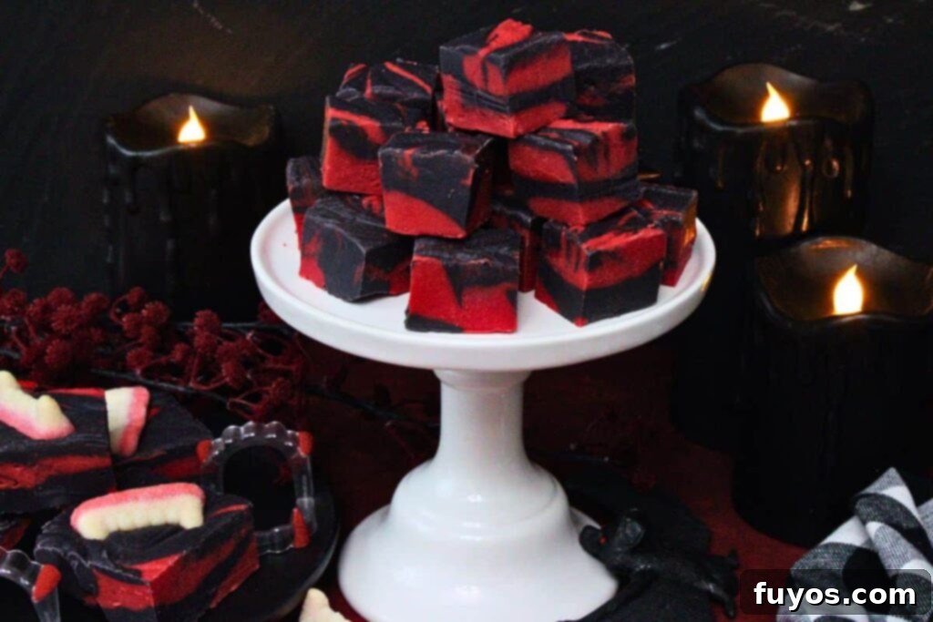Vampire Fudge: A Sinfully Simple Halloween Indulgence 10 Stacked squares of red and black vampire fudge on a white tiered stand, set against a dark, candlelit Halloween backdrop, creating a moody and festive atmosphere.