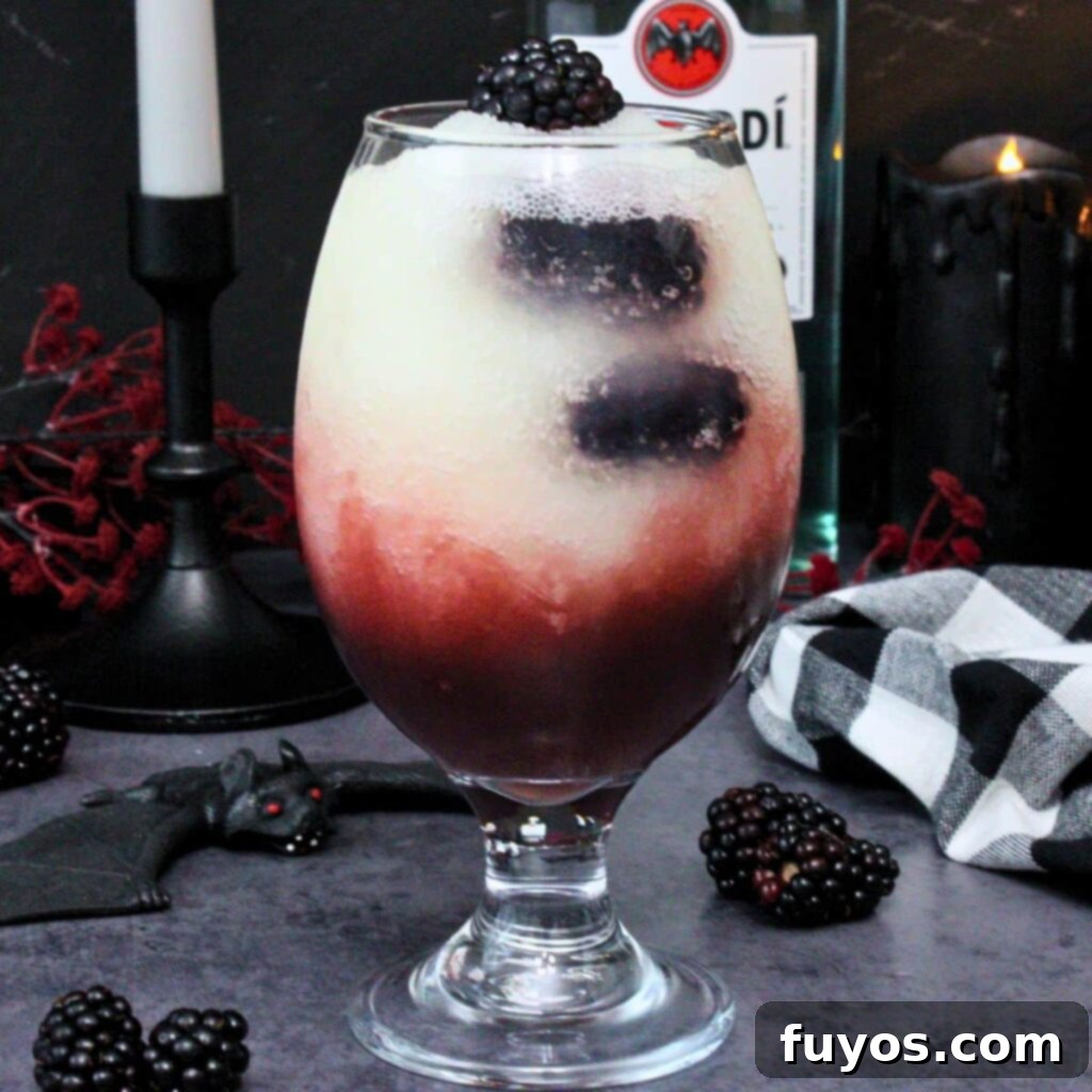 Make Your Own Dracula Juice for Halloween 2 Applebee's Dracula Juice copycat recipe, a vibrant red and white layered frozen cocktail, perfect for Halloween parties.