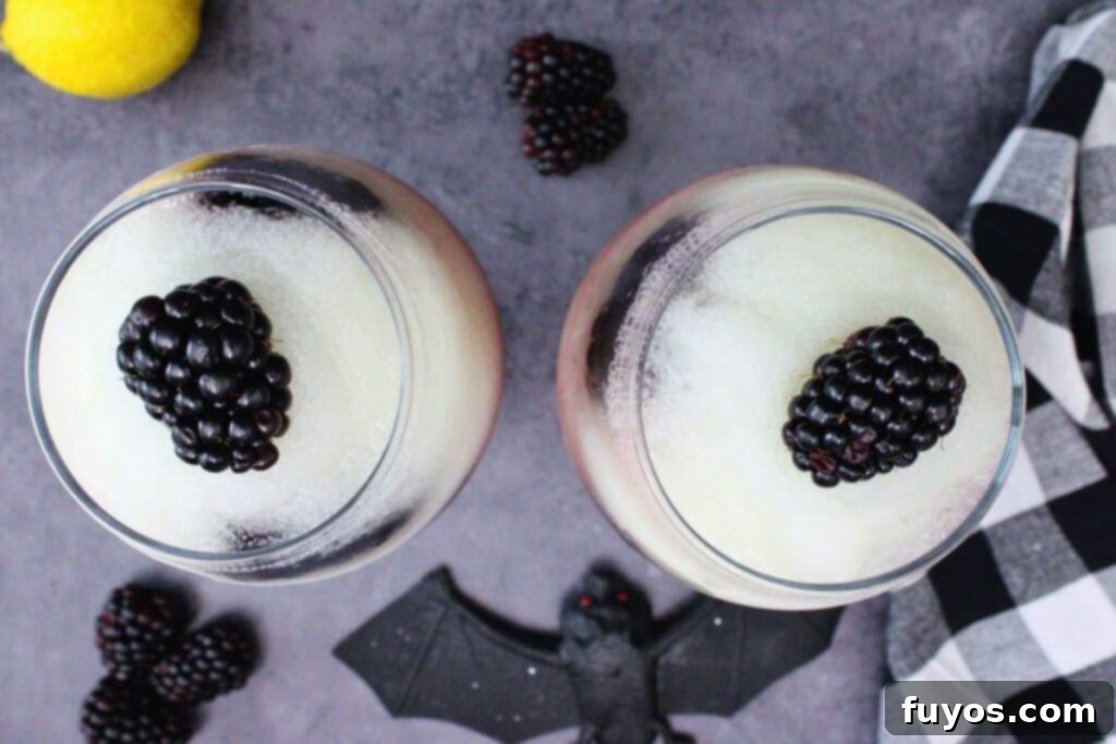 Make Your Own Dracula Juice for Halloween 8 Overhead view of two Applebee's Dracula Juice cocktails, showcasing the frozen lemonade layer with a fresh blackberry garnish on top.