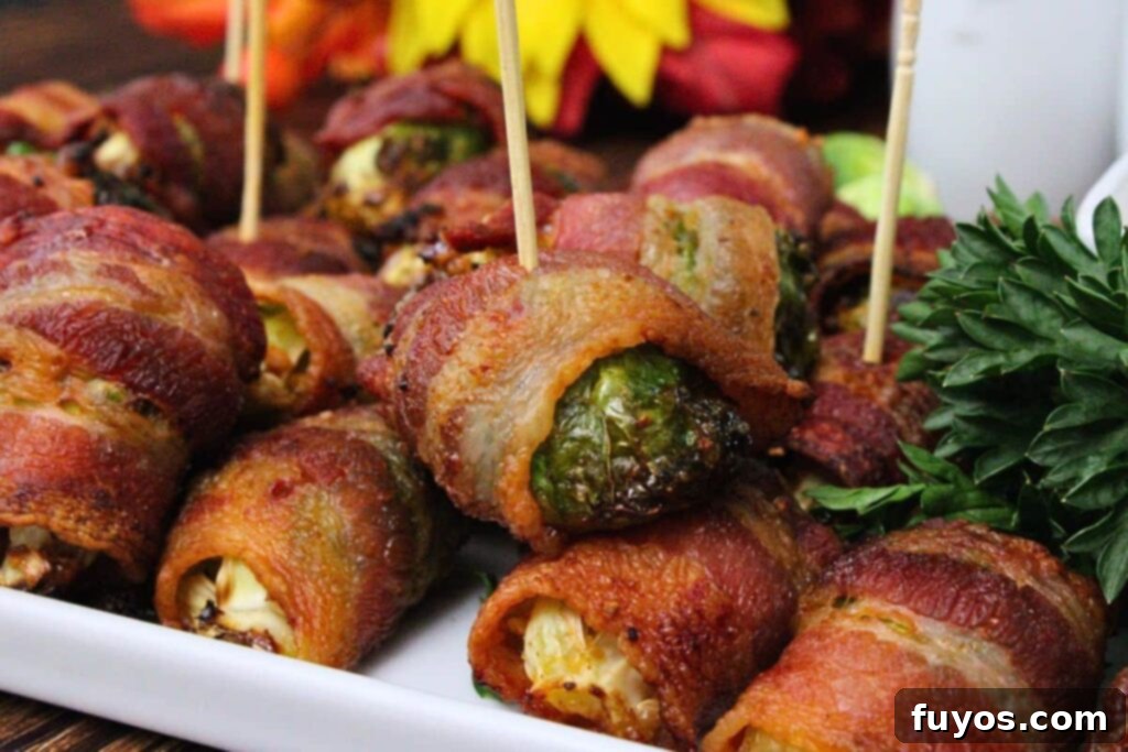 Closeup view of crispy bacon wrapped brussel sprouts with toothpicks on a serving plate