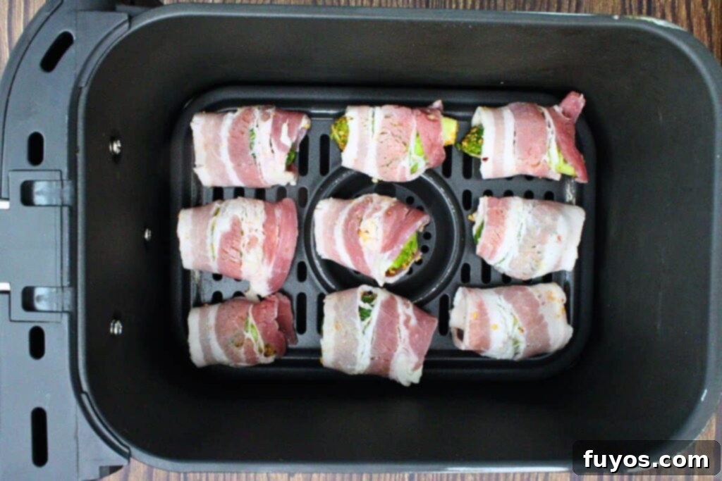 Placing bacon wrapped brussel sprouts into air fryer basket