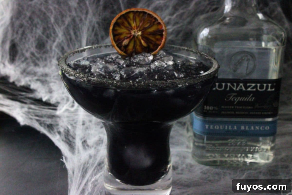 black margarita next to tequila bottle on a halloween spiderweb background