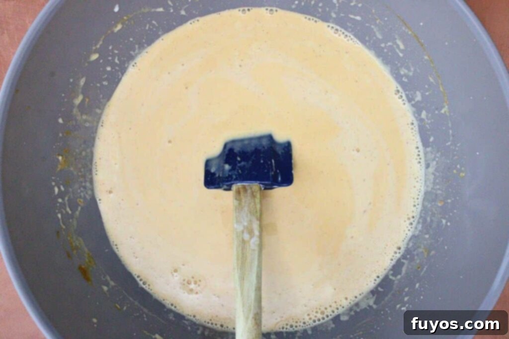 slowly whisk hot cream into pumpkin mixture
