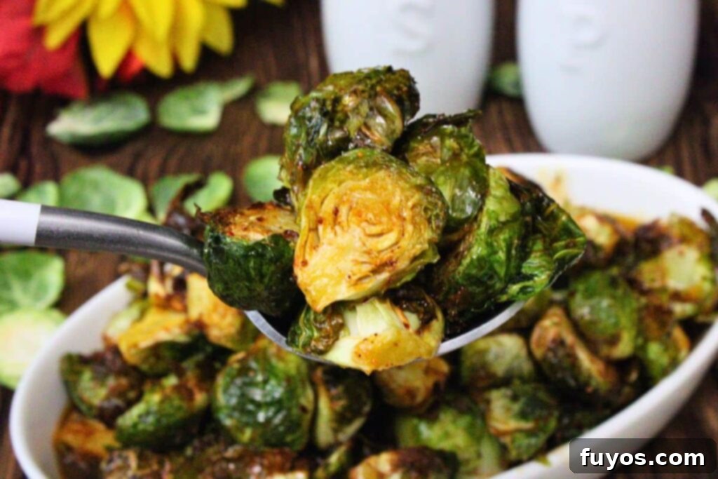 holding up a spoonful of air fryer longhorn brussel sprouts