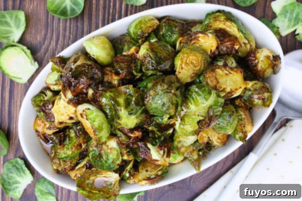 overhead view of copycat longhorn brussel sprouts in an oval serving bowl on a wooden counter