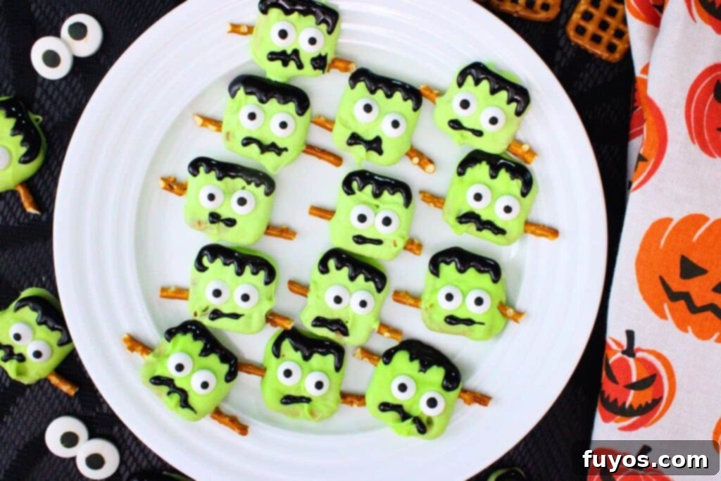 overhead view of several frankenstein pretzels on a plate surrounded by candy eyes