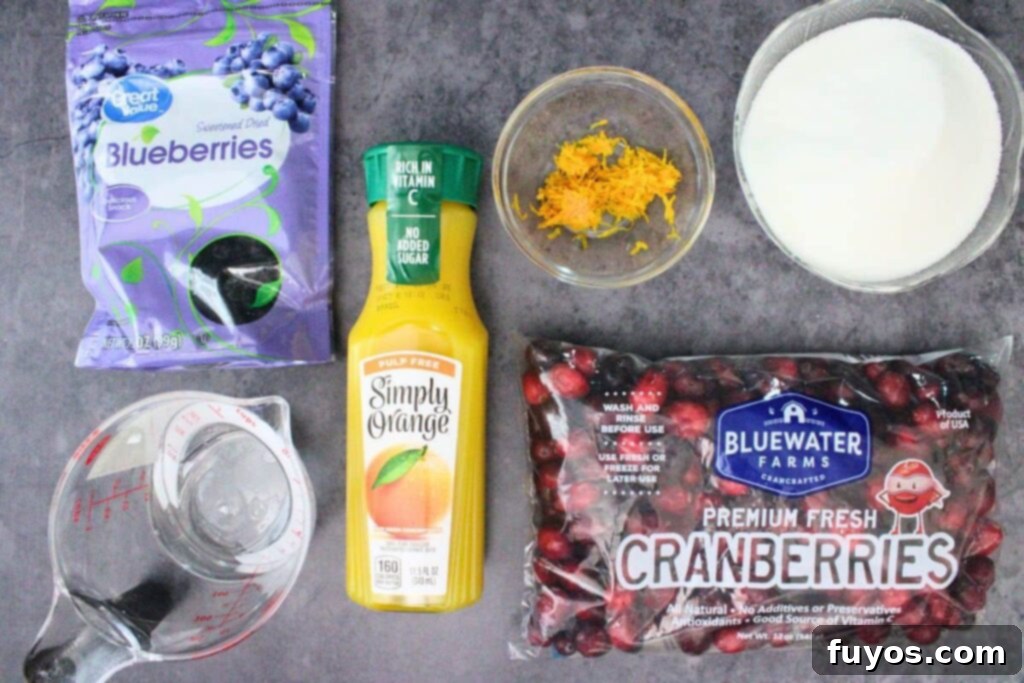 Fresh ingredients for homemade microwave cranberry sauce, including cranberries, blueberries, oranges, and sugar