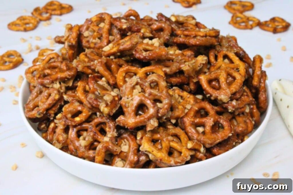 butter toffee pretzels piled up in a large bowl with more pretzels scattered around the counter