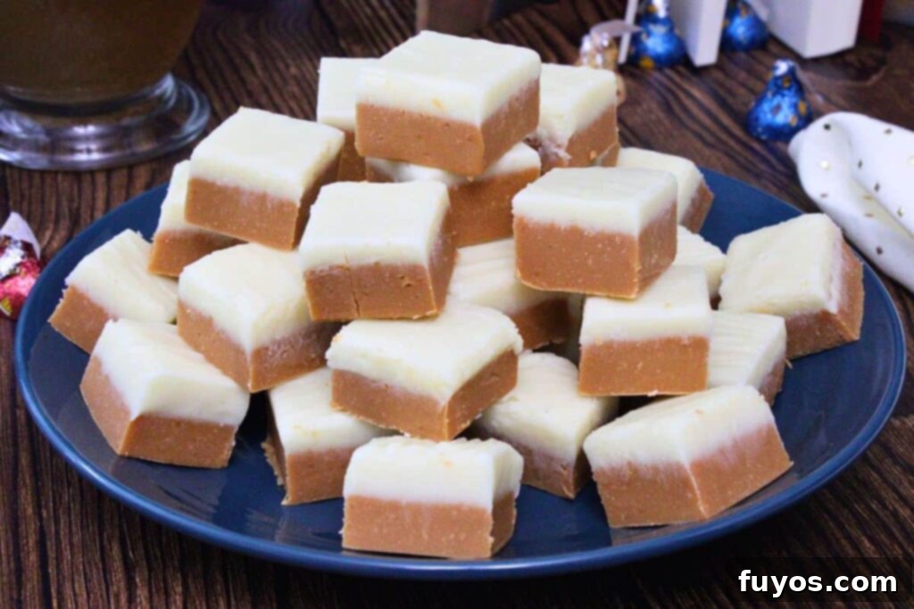 closeup view of butterbeer fudge squares stacked up on a plate showing dual color layers