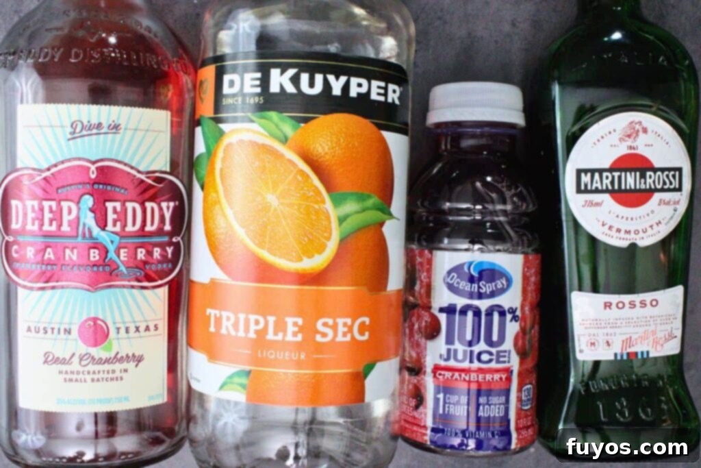 Effortless Holiday Cranberry Martini Vodka Drink 4 Ingredients laid out for making a Cranberry Martini: vodka, cranberry juice, triple sec, and vermouth.