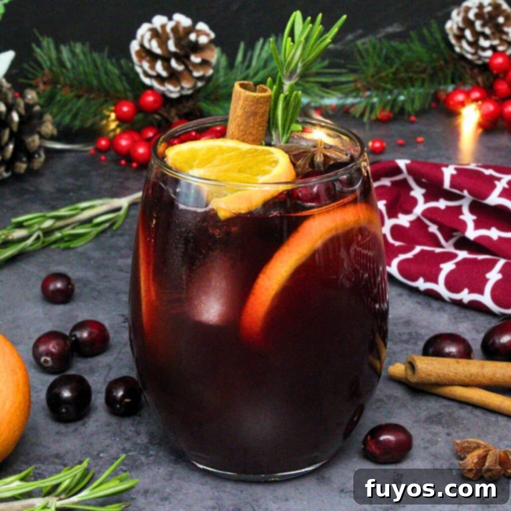 Vibrant cranberry sangria, garnished with fresh cranberries, orange slices, and a sprig of rosemary, perfect for festive holiday celebrations.