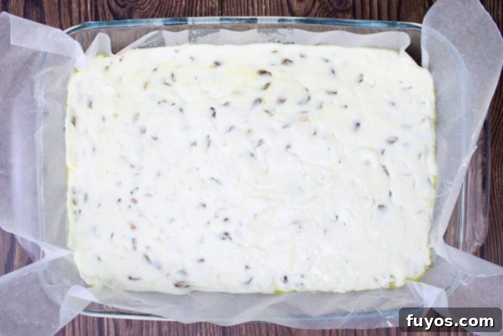 Pouring the homemade pistachio nougat mixture into a prepared pan