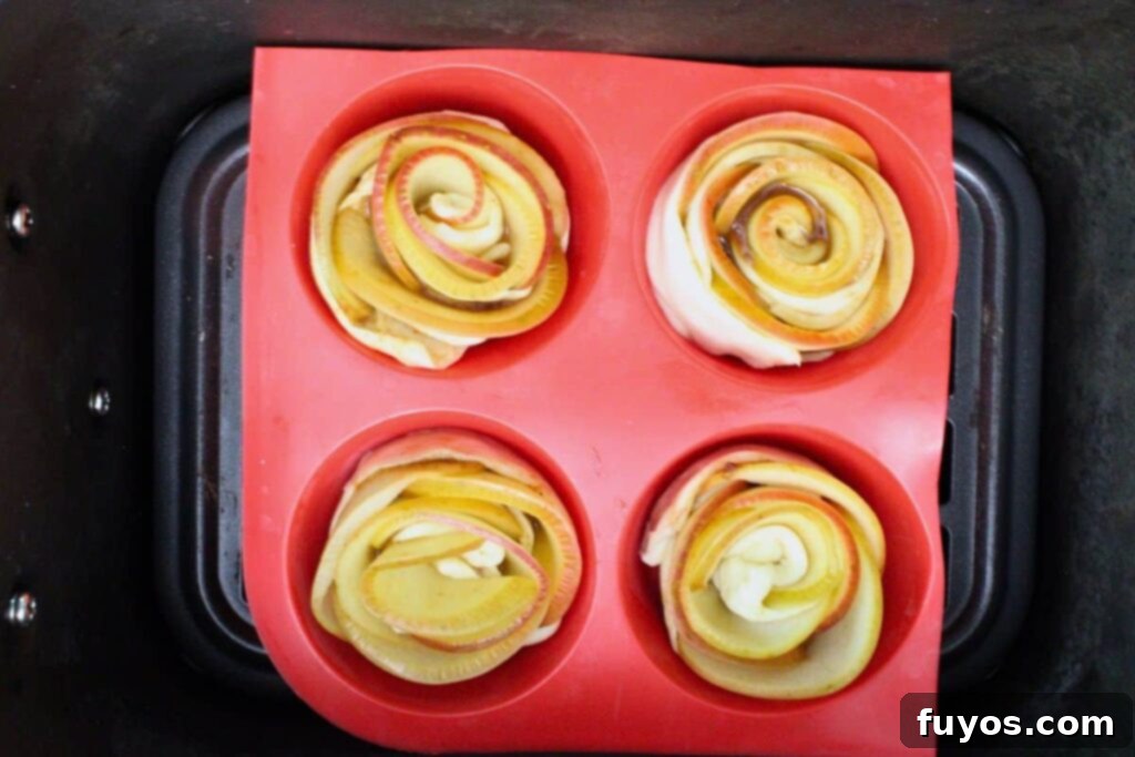 Place apple roses in muffin cups inside the air fryer basket